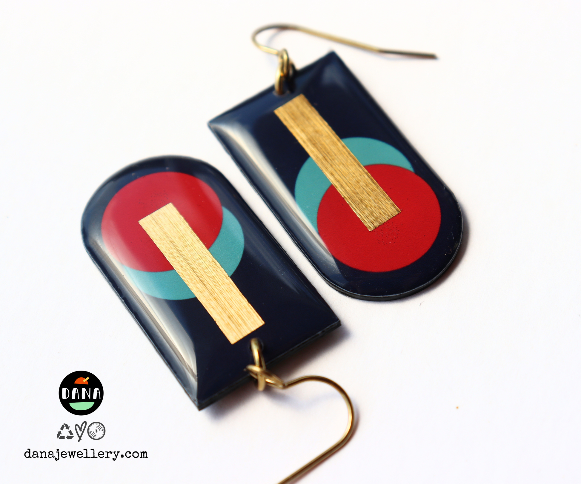 A pair of abstract geometric earrings handmade in Ireland from recycled vinyl records, featuring deep navy, red, and blue-green colours with a gold accent.