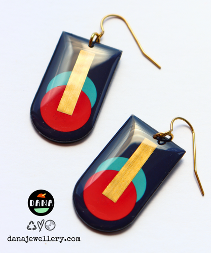 A pair of abstract geometric earrings handmade in Ireland from recycled vinyl records, featuring deep navy, red, and blue-green colors with a gold accent.