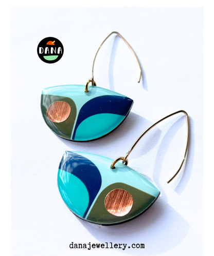 A pair of retro inspired drop earrings featuring geometric patterns in blue, green, and teal colours with copper accents with long stylish hooks, made in Ireland from recycled vinyl record, displayed against a white background.