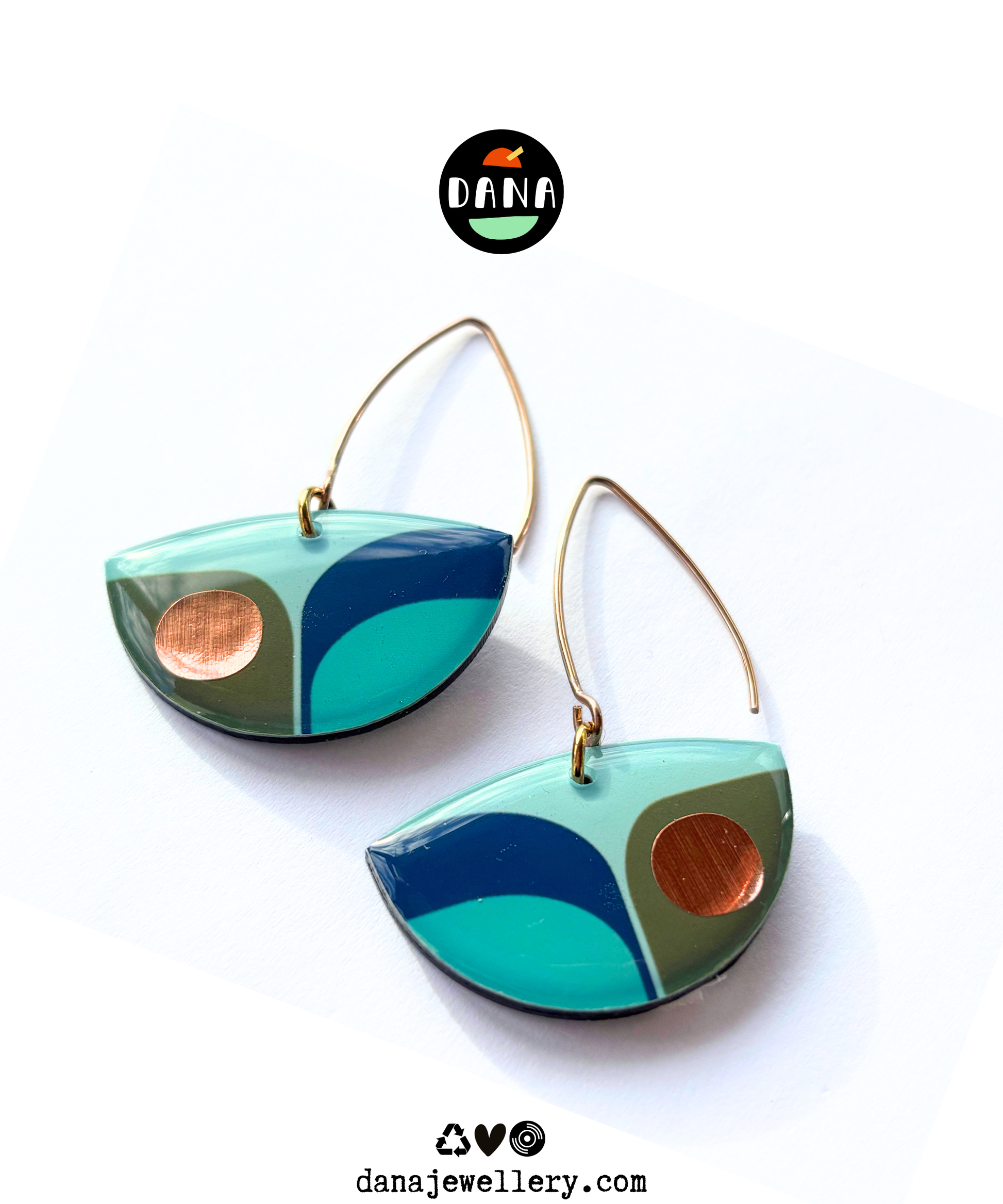 A pair of retro inspired drop earrings featuring geometric patterns in blue, green, and teal colours with copper accents with long stylish hooks, made in Ireland from recycled vinyl record, against a white background.