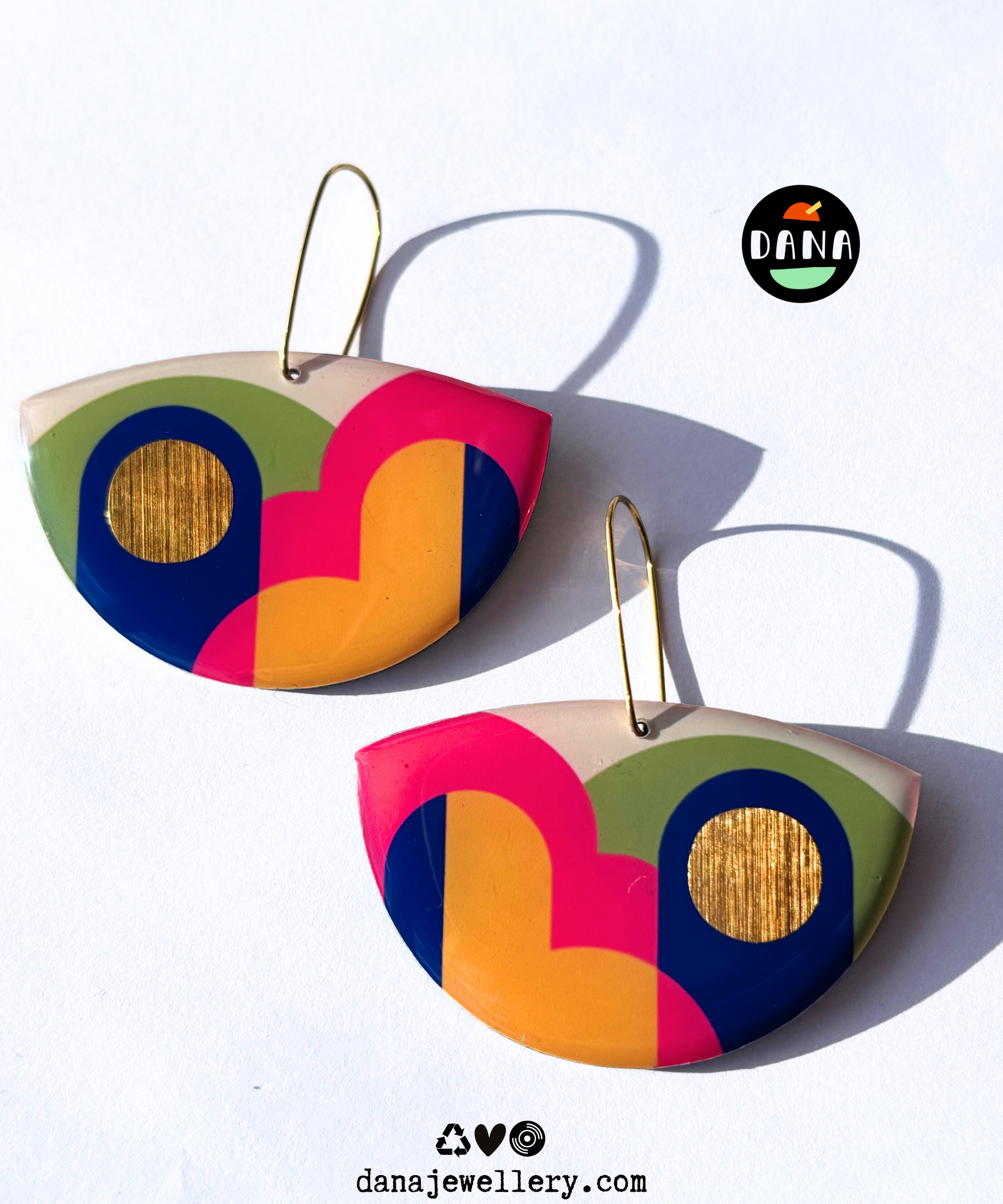 A pair of colourful statement funky art earrings handmade in Ireland by DANA Jewellery featuring geometric patterns in blue, pink, green, yellow, gold.