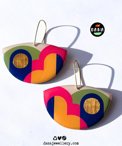 A pair of colourful statement funky art earrings handmade in Ireland by DANA Jewellery featuring geometric patterns in blue, pink, green, yellow, gold.