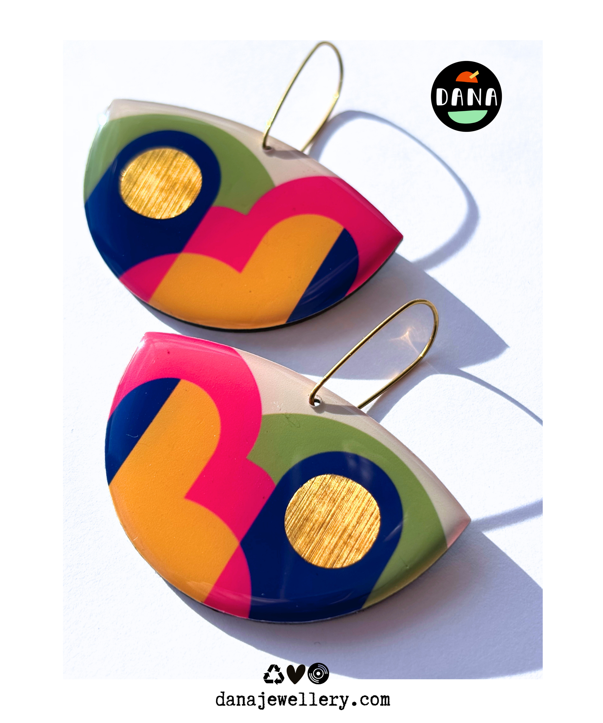 A pair of colourful statement funky art earrings handmade in Ireland by DANA Jewellery featuring geometric patterns in blue, pink, green, yellow, gold.