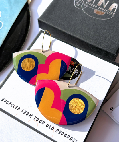 A pair of colourful statement funky art earrings handmade in Ireland by DANA Jewellery featuring geometric patterns in blue, pink, green, yellow, gold.