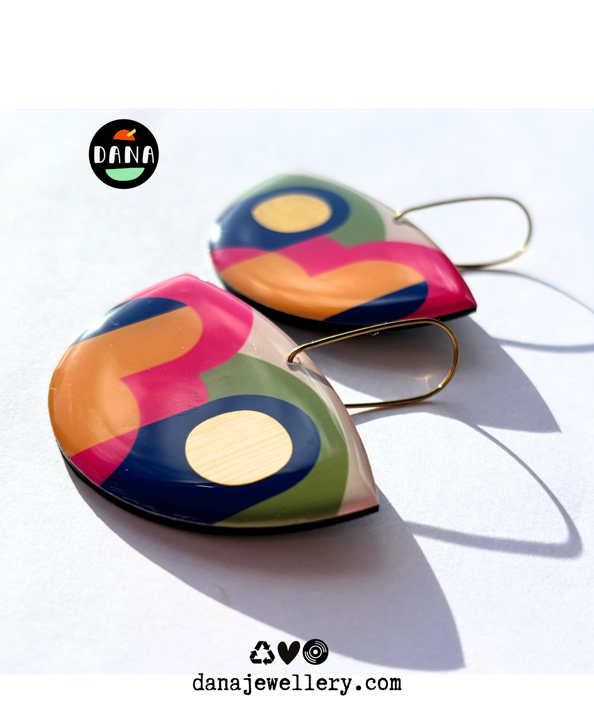 A pair of colourful statement funky art earrings handmade in Ireland by DANA Jewellery featuring geometric patterns in blue, pink, green, yellow, gold.